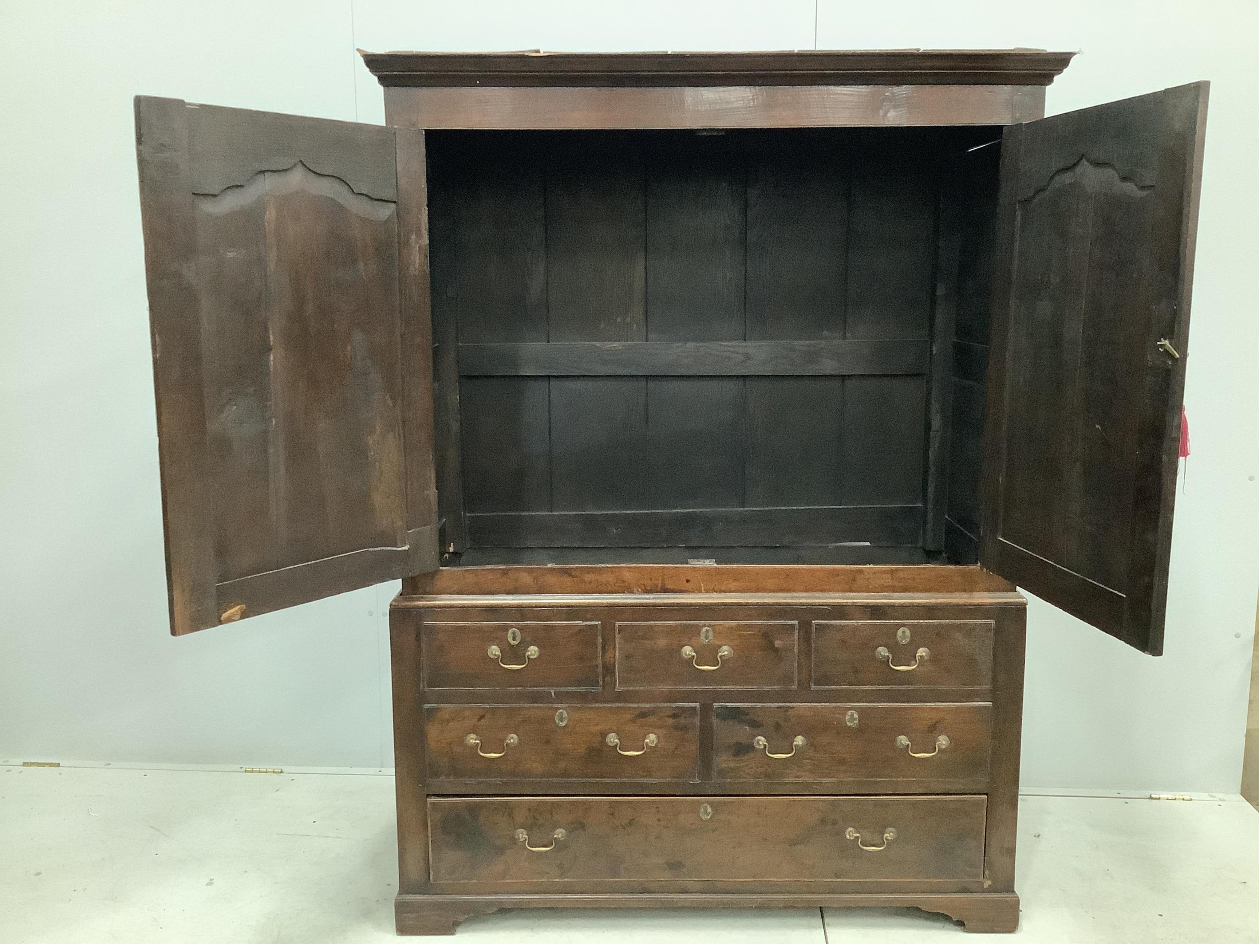 An early 18th century and later oak press cupboard with two doors and one base drawer, width 140cm, height 185cm. Condition - fair to good